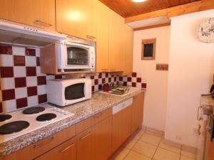a kitchen with a stove and a microwave at Appartement Huez, 2 pièces, 6 personnes - FR-1-405-162 in LʼHuez