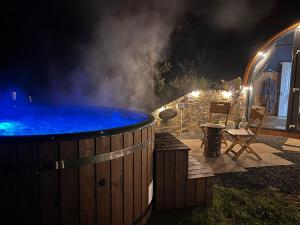 a hot tub in a yard at night at Hilltop Hideaway - Secluded pod with private hot tub in Newry