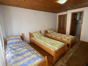 ドブリニシュテにあるTsvetkovi Guest Houseのベッド3台が備わる部屋