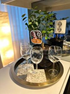 ヘルシンキにあるLovely apartment near the Beachのカウンターに4杯のワイングラスを入れたトレイ