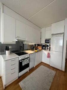een keuken met witte kasten en een fornuis met oven bij Lovely apartment near the Beach in Helsinki