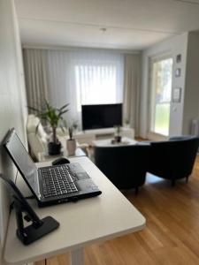 een laptop op een tafel in een woonkamer bij Lovely apartment near the Beach in Helsinki