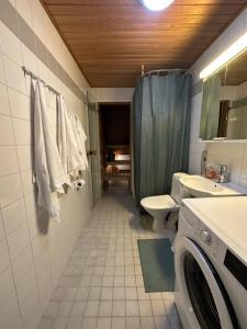 a bathroom with a toilet sink and a washing machine at Lovely apartment near the Beach in Helsinki