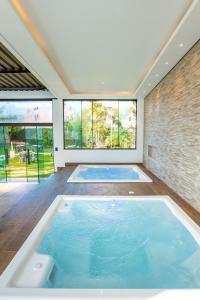 uma grande piscina num quarto com duas grandes janelas em Hotel & Pousada Sonho Meu em Florianópolis