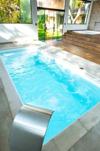 een zwembad in een huis met blauw water bij Hotel & Pousada Sonho Meu in Florianópolis