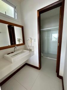 a bathroom with a sink and a mirror and a shower at Pousada Aroeira Eco in Morro de São Paulo