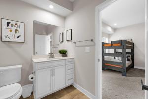 a bathroom with a toilet and a sink and a mirror at Stunning and Spacious 4-bedroom Townhome! The Dye at Barefoot Resort 403 in North Myrtle Beach