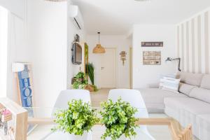 - un salon avec un canapé blanc, une table et des chaises dans l'établissement Alfamar Apartment at Praia da Falesia, à Albufeira
