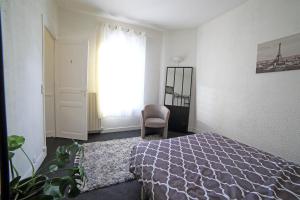 a bedroom with a bed and a chair and a window at Chambre 1, calme, 1 station de PARIS, bureau in Maisons-Alfort