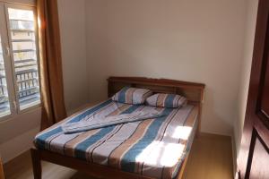 a small bed in a room with a window at Schitterend gelegen tweekamerwoning in Paramaribo