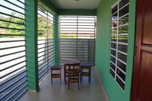 a table and chairs in a room with windows at Schitterend gelegen tweekamerwoning in Paramaribo