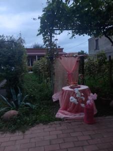 a pink table with flowers on it in a yard at Cottage and Gigo Papa's Wine Cellar in Kvareli
