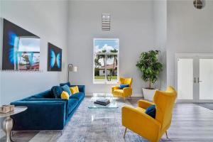 a living room with a blue couch and yellow chairs at Kendall Vacation Luxury Home in Miami