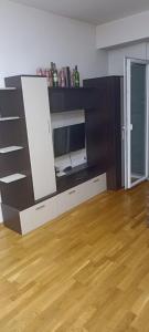 a living room with a television and a wooden floor at Wonderful Studio Apartment in Skopje center in Skopje +8 photos
