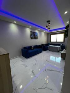 - un salon avec un canapé et un plafond bleu dans l'établissement Appartement Jardins de Tanger , 2 chambres, à Tanger