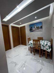 jadalnia ze stołem i krzesłami oraz marmurową podłogą w obiekcie Appartement Jardins de Tanger , 2 chambres w mieście Tanger