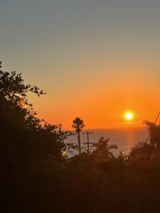 een zonsondergang boven de oceaan met een palmboom bij Contemporary Ocean Sunset Views with Firepit Pt Loma close to PLNU in San Diego