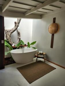 a bathroom with a bath tub with a tree in the corner at Outro Beach Hotel Cumbuco in Cumbuco