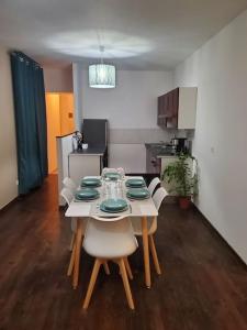 uma mesa de jantar com cadeiras e uma cozinha em Appartement moderne en ville em Armentières