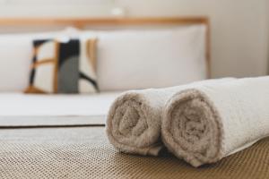 a roll of towels sitting on a bed at MiCo Apartment in Fiera Milano City in Milan