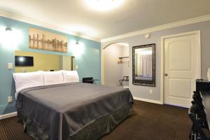 Habitación de hotel con cama y espejo en Lodge at 32nd, en San Diego