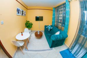 a living room with a green couch and a table at cla bnb in Kisumu