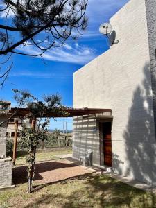 a white building with a satellite on the side of it at Primafila in Sauce de Portezuelo