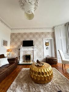 uma sala de estar com um sofá e uma lareira em THE LAZY LION - Spacious 2 Bedroom - Town Centre Holiday Home Apartment em Port Glasgow