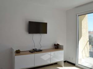 - une télévision sur un mur blanc dans l'établissement Appartement Fleury, 2 pièces, 4 personnes - FR-1-229D-12, à Fleury