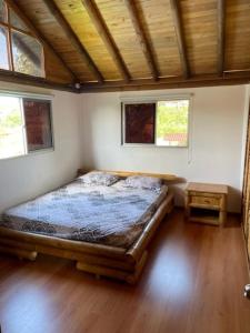 a bedroom with a bed in a room with two windows at Cabaña Higueron Tennis Club in Turbaco