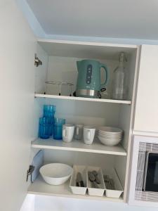a cupboard with bowls and other kitchen items in it at C9 Magnífico apartamento en zona tranquila in Madrid