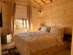 een slaapkamer met een bed in een blokhut bij Rise In Valley in Ifrane