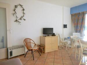 a living room with a tv and a table and chairs at Appartement Le Lavandou, 2 pièces, 4 personnes - FR-1-251-345 in Le Lavandou