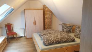 a attic bedroom with a bed and a chair at Ferienhaus Mariental in Rudolstadt