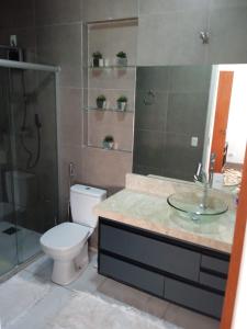 a bathroom with a toilet and a sink and a shower at Casa Bela no Rita Vieira in Campo Grande +28 photos