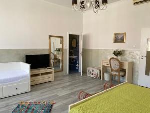 Schlafzimmer mit einem Bett, einem TV und einem Spiegel in der Unterkunft Penzión Bihari in Dunajská Streda