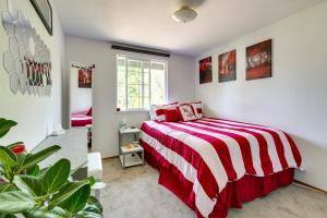 a bedroom with a bed with a red and white striped blanket at Lynwood Vacation Rental with Outdoor Living Galore! in Lynnwood