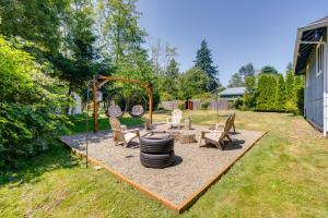 um quintal com um parque infantil com uma pilha de pneus em Lynwood Vacation Rental with Outdoor Living Galore! em Lynnwood