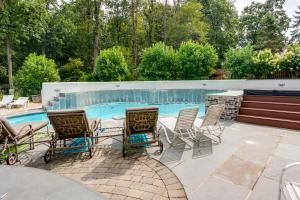 un patio con sillas y una mesa junto a la piscina en Centrally Located Harleysville Home with Pool, en Harleysville