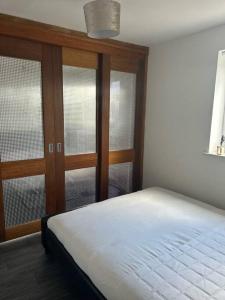 1 dormitorio con 1 cama y algunas ventanas en Entire Apartment in Greater Manchester en Mánchester