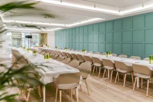a row of tables and chairs in a room with green walls at Hotel Harmonia by Dukley in Budva