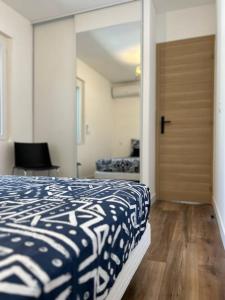 Un dormitorio con una cama azul y blanca y una puerta en Appartement Jacuzzi, en Narbona
