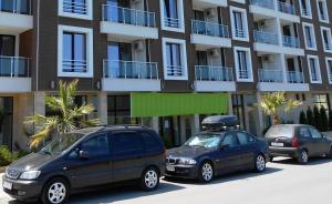 two cars parked in a parking lot in front of a building at Stamopolu Lux ground floor in Primorsko