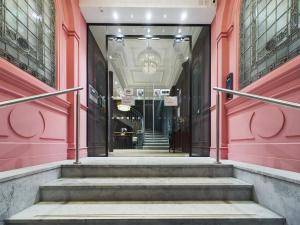 a hallway in a building with pink walls and stairs at Classy 2bedroom City Centre Apt in Manchester