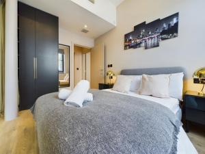 1 dormitorio con 2 camas y almohadas blancas en Classy 2bedroom City Centre Apt, en Mánchester