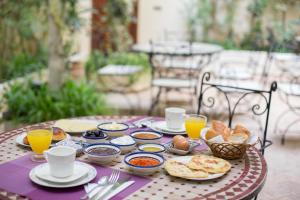 a table with breakfast foods and drinks on it at Riad Fes Allouch in Fez