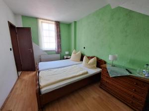 a bedroom with two beds and a green wall at Hotel zum Hirsch in Lucka
