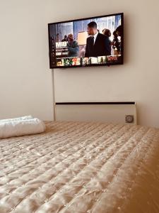 a bedroom with a flat screen tv on the wall at Deluxe City Apt, Beautiful River View,Free Parking in Leeds