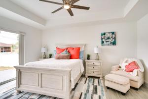 a white bedroom with a bed and a chair at Comfy Lehigh Acres Getaway with Yard and Fireplace in Lehigh Acres