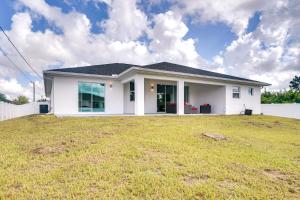 a white house with a large yard at Comfy Lehigh Acres Getaway with Yard and Fireplace in Lehigh Acres